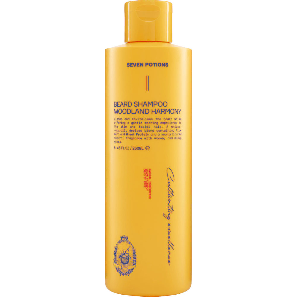 Product photo of Seven Potions Beard Shampoo Woodland Harmony in a vibrant yellow-orange bottle on a plain background featuring dark text, a small crest design, and vertical script "Cultivating excellence"